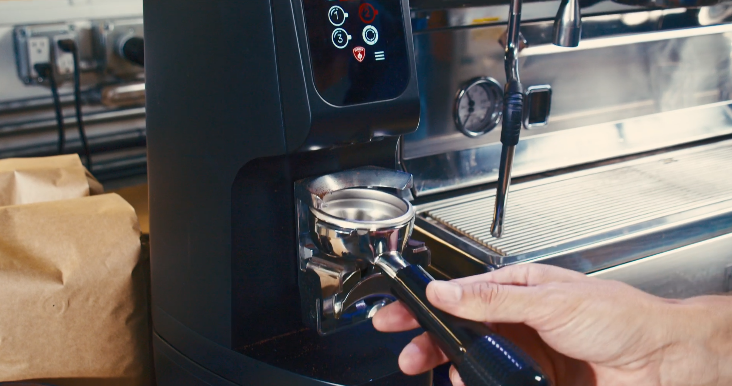 Person using a coffee machine with a focus on the espresso shot being made.