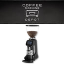 Coffee grinder with coffee beans on a white background, featuring the Coffee Machine Depot logo.
