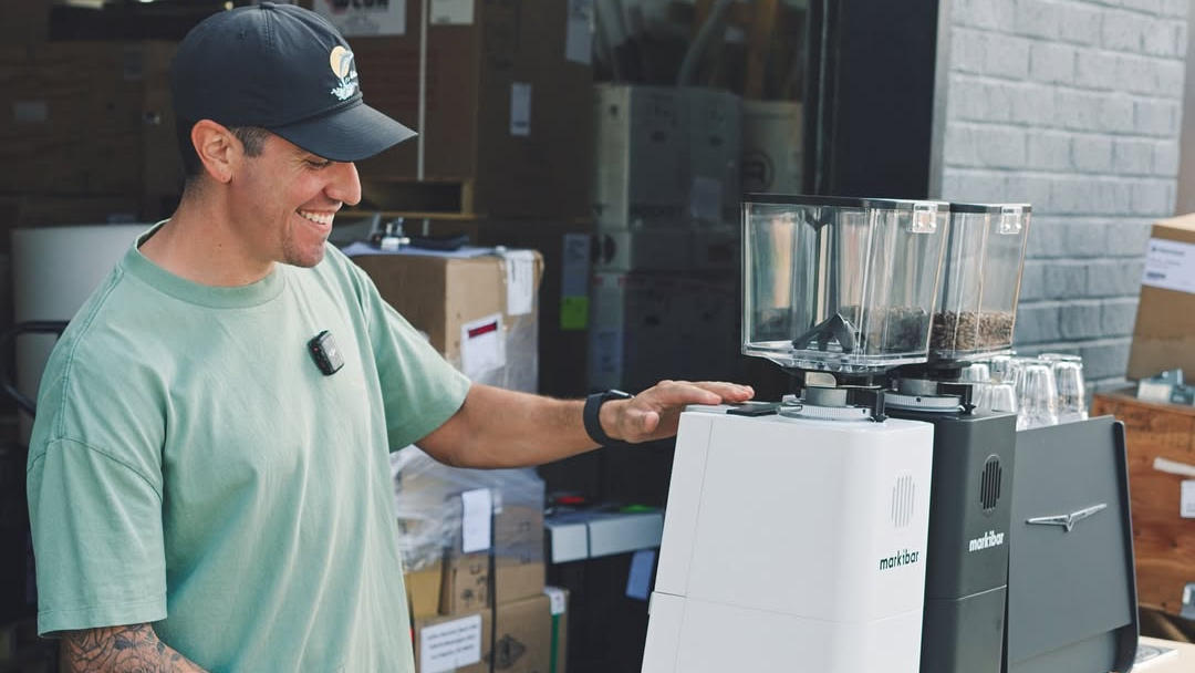 Man operating a coffee grinder in a workshop setting